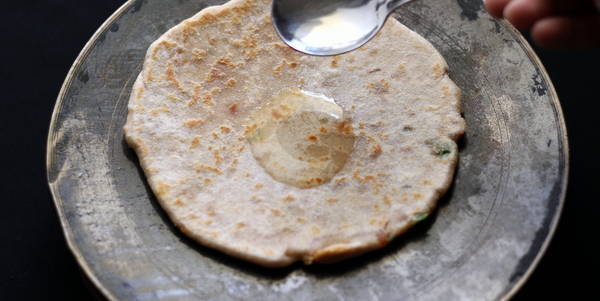 stuffed paratha applying oil on bread